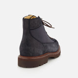 A pair of BRUNELLO CUCINELLI Suede Ankle Boots, featuring a rich dark blue suede upper with lace-up design and a brown rubber sole, is shown from the back against a white background.