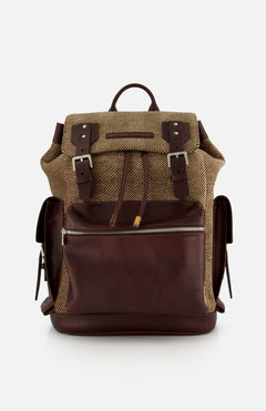 A BRUNELLO CUCINELLI Vintage Chevron-effect Backpack, featuring a brown leather and herringbone fabric design with front zipper pocket, buckle straps, leather inserts, adjustable shoulder straps, and side pockets, is displayed against a plain white background.