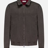 The BRUNELLO CUCINELLI Wool Bomber Jacket is showcased against a plain white background, featuring a dark brown hue with a zip-up front, classic collar, long sleeves, and an elasticized hem. Inspired by Brunello Cucinelli’s renowned craftsmanship, this virgin wool bomber is finished with a distinctive red label tag on the inside of the collar for an added touch of refinement.