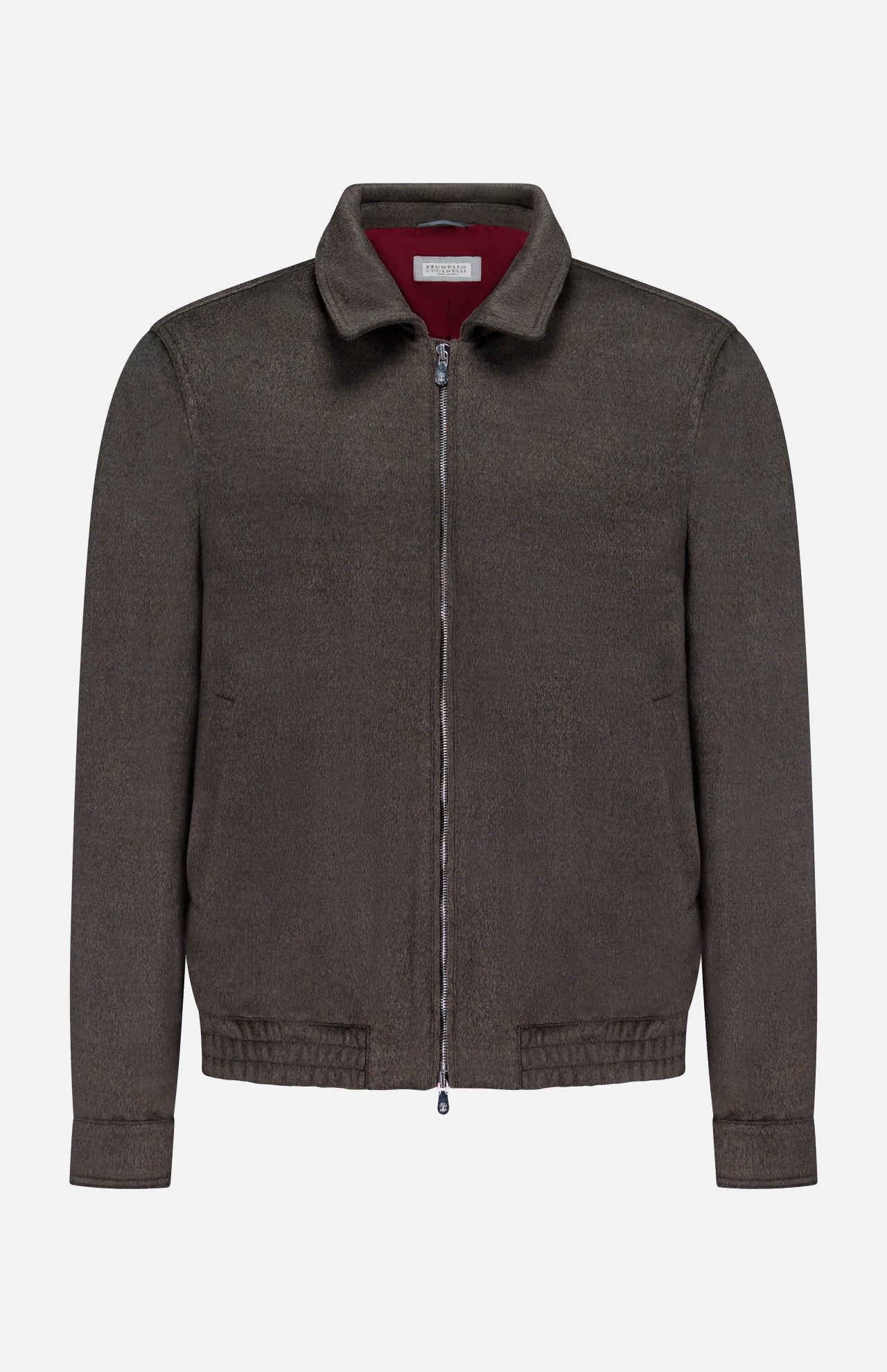 The BRUNELLO CUCINELLI Wool Bomber Jacket is showcased against a plain white background, featuring a dark brown hue with a zip-up front, classic collar, long sleeves, and an elasticized hem. Inspired by Brunello Cucinelli’s renowned craftsmanship, this virgin wool bomber is finished with a distinctive red label tag on the inside of the collar for an added touch of refinement.