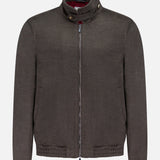 The BRUNELLO CUCINELLI Wool Bomber Jacket features a dark brown hue, expertly crafted from luxurious virgin wool. Designed with a zip-up front, high collar, button detail, and two side pockets, this refined outerwear staple draws inspiration from Brunello Cucinelli’s signature style and is displayed against a plain white background.