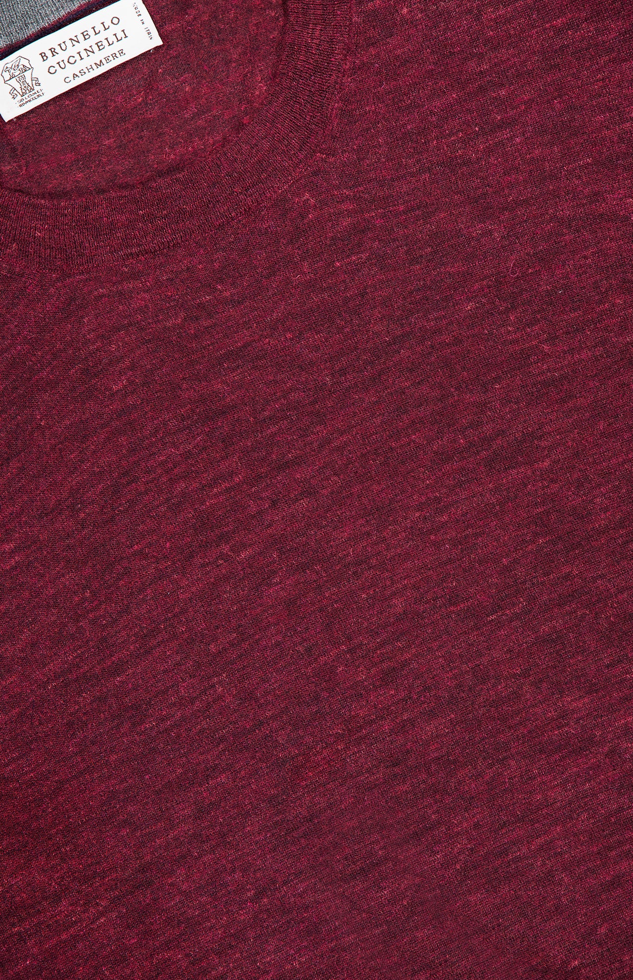 Close-up of a men's Cashmere-blend Long Sleeve Sweater in luxurious maroon tones, featuring the distinctive BRUNELLO CUCINELLI label in the top left corner. The rich burgundy knit texture of this BRUNELLO CUCINELLI sweater is clearly displayed.