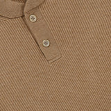 Close-up of the Cashmere Polo Sweater by BRUNELLO CUCINELLI in light brown ribbed knit, featuring a Henley collar with two beige buttons and a small BRUNELLO CUCINELLI label inside the collar.