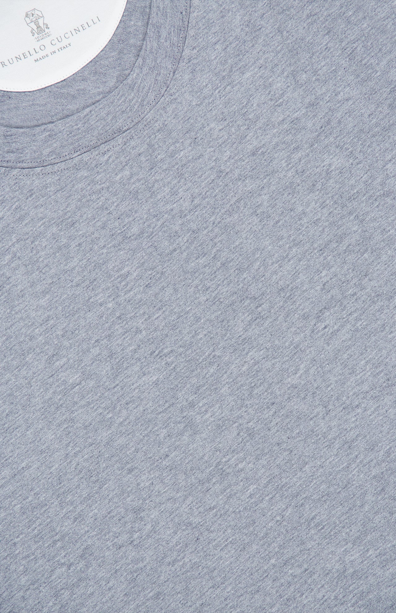 Here’s the rewritten sentence using the provided product data: A close-up of a heather gray BRUNELLO CUCINELLI Cotton Crewneck T-Shirt highlights the refined construction and slim fit, with part of the collar and a “Made in Italy” label visible in the top left corner.