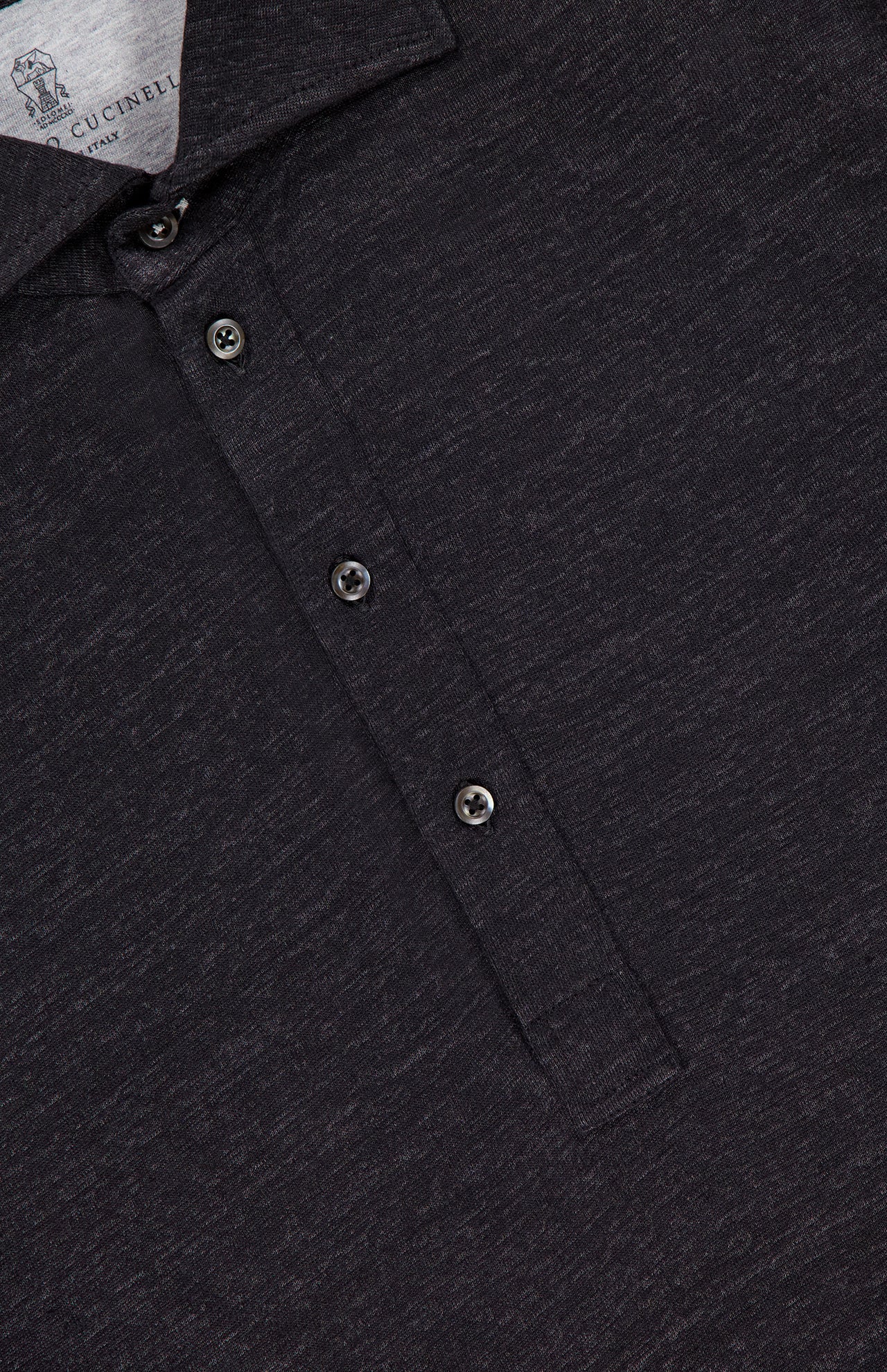 Close-up of the BRUNELLO CUCINELLI Cotton Linen Short Sleeve Polo Shirt in dark grey, featuring a three-button placket, visible collar, and textured heathered fabric. Part of the inside tag is shown at the top left.