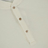Close-up of a cream-colored Cotton Long Sleeve Henley T-shirt with a waffle knit, partial button placket, and three metallic buttons. The collar label shows BRUNELLO CUCINELLI, Made in Italy.