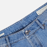 Close-up of the waist area of the Button Fly Denim Jeans by BRUNELLO CUCINELLI, crafted from premium light blue Italian denim with a visible metal button and belt loops. A white label inside the waistband displays the BRUNELLO CUCINELLI name, emphasizing the jeans' refined vintage treatment.