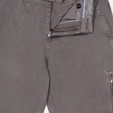 Close-up of BRUNELLO CUCINELLI Dyed Zigzag Cargo Trousers in light brown cotton, with the fly open to reveal a zipper, two buttons, and part of the waistband and pocket lining.