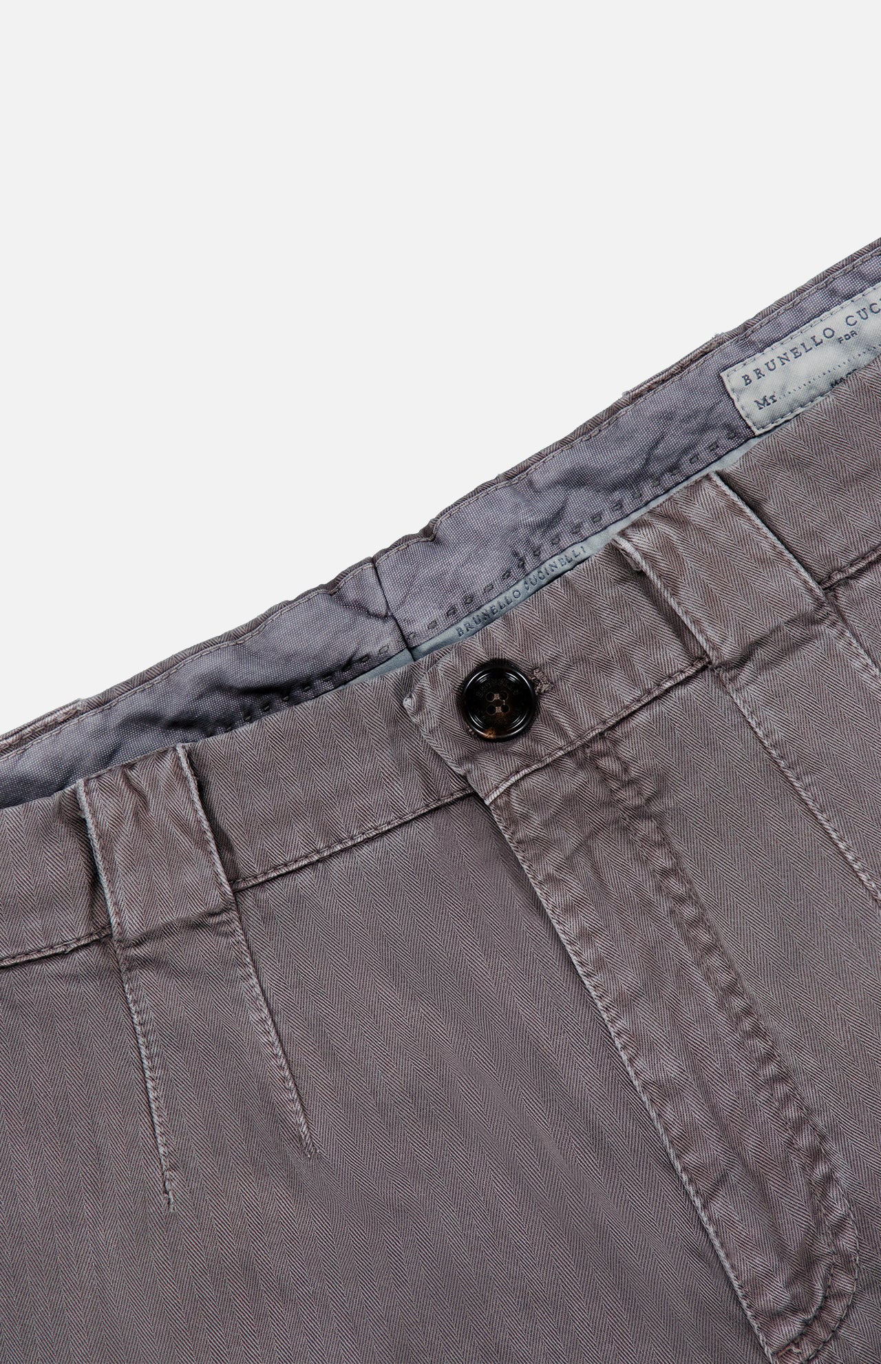 Close-up of the waistband and button of the BRUNELLO CUCINELLI Dyed Zigzag Cargo Trousers, featuring grey cotton chevron fabric with belt loops, visible stitching, and a partially revealed inner fabric label.