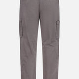 Back view of BRUNELLO CUCINELLI Dyed Zigzag Cargo Trousers in grey cotton, featuring a chevron pattern, two upper back flap pockets, side cargo pockets on each leg, belt loops, and straight legs. These Italian cargo trousers are laid flat against a white background.
