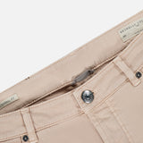 Close-up of the waistband and button of the beige Button Fly Dyed Denim Pants from BRUNELLO CUCINELLI, highlighting the label with brand and size details. The Italian denim pants are unbuttoned against a white background.