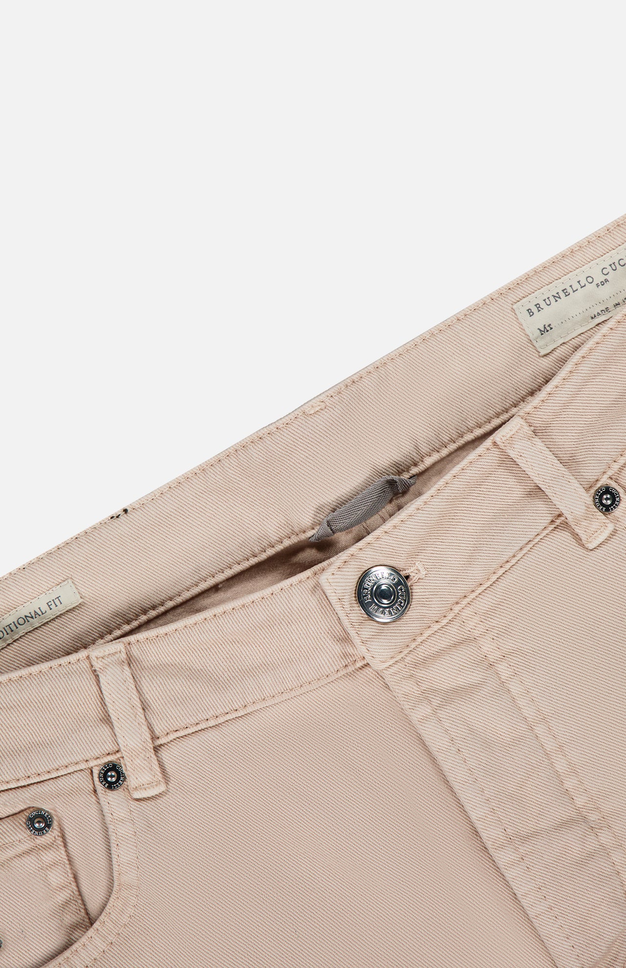 Close-up of the waistband and button of the beige Button Fly Dyed Denim Pants from BRUNELLO CUCINELLI, highlighting the label with brand and size details. The Italian denim pants are unbuttoned against a white background.