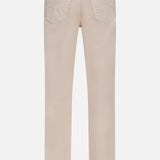 Back view of the Button Fly Dyed Denim Pants by BRUNELLO CUCINELLI in light beige, expertly crafted from premium Italian denim and featuring two back pockets along with a brown leather patch on the waistband—a signature detail that reflects the brand’s refined style.