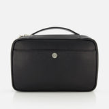 The BRUNELLO CUCINELLI Leather Dopp Kit is a rectangular black leather bag made in Italy, featuring a top handle, front pocket, and a small round metallic logo at the center, shown against a plain white background.
