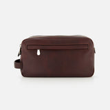 The BRUNELLO CUCINELLI Leather Dopp Kit, crafted in Italy from brown leather, showcases a rectangular silhouette with a front zip pocket, top zipper closure, and convenient side handle—ideal for organizing your travel essentials and beautifully presented against a white background.
