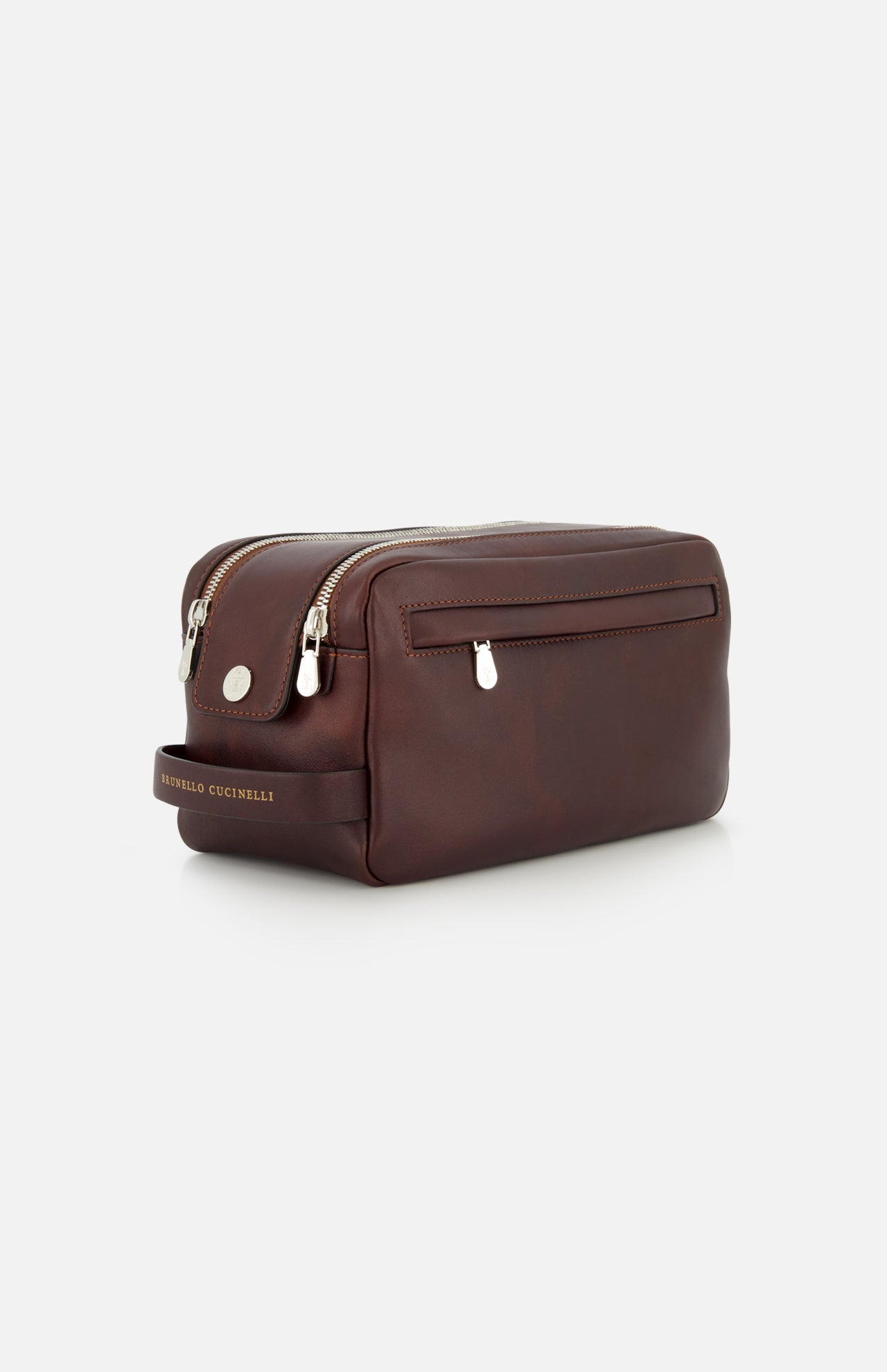 A brown Leather Dopp Kit by BRUNELLO CUCINELLI, crafted in Italy, featuring two zippered compartments, a front pocket, and a side handle embossed with the brand name in gold. This elegant travel accessory is displayed against a plain white background.