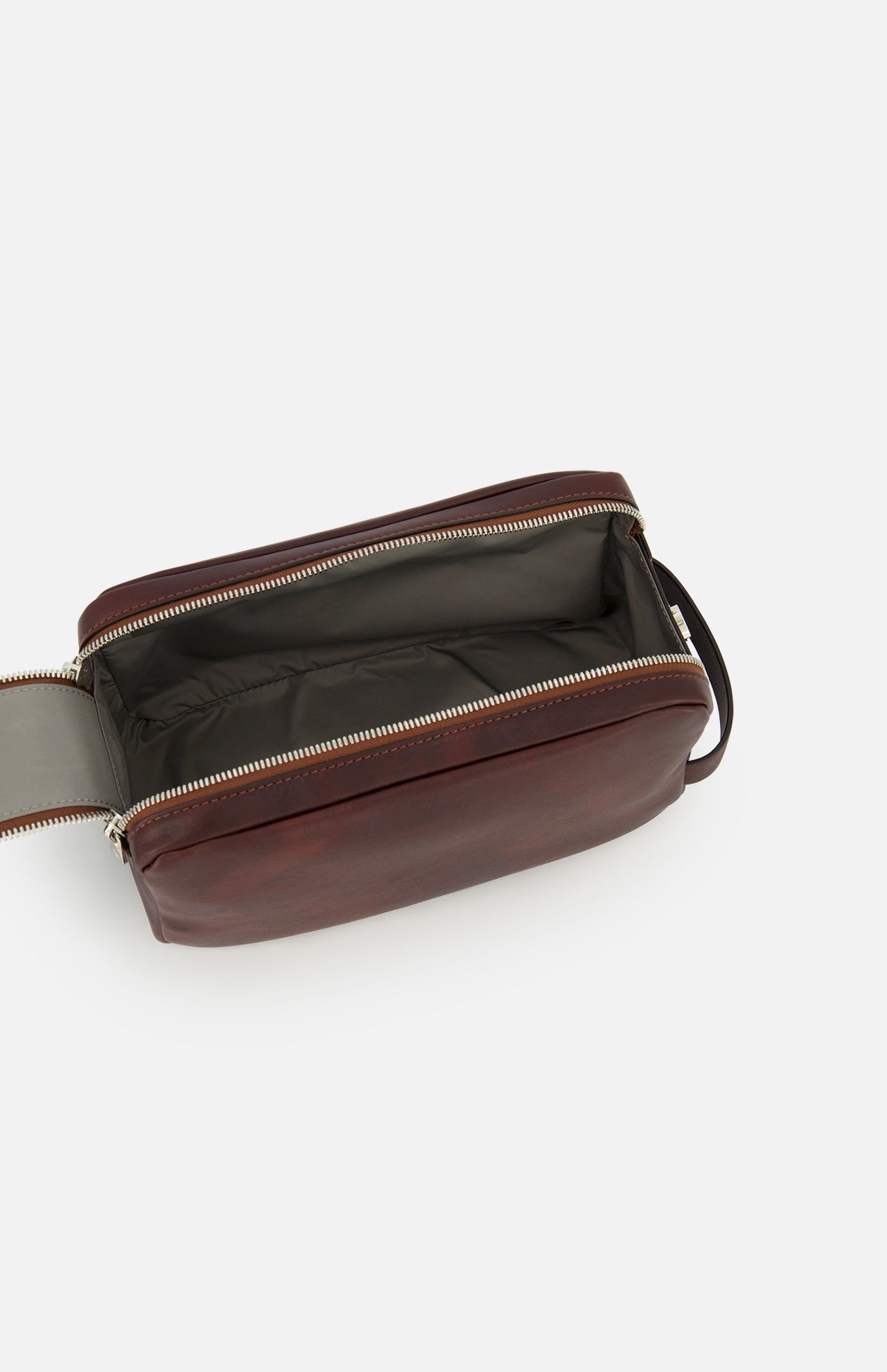 The BRUNELLO CUCINELLI Leather Dopp Kit, crafted from brown leather in Italy, is displayed open against a plain white background to showcase its spacious, lined interior and zippered closure. This elegant toiletry bag is an essential addition to your travel accessories.