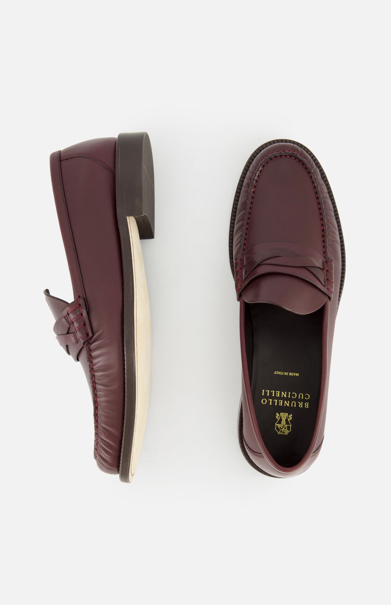 A pair of BRUNELLO CUCINELLI Leather Woven Band Loafers in classic burgundy leather, shown from the side and top, feature a black insole with "BRUNELLO CUCINELLI Made in Italy" in gold lettering.