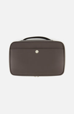 The BRUNELLO CUCINELLI Leather Travel Bag is a brown leather briefcase with a top handle and a front pocket, distinguished by a small circular silver emblem at its center. Exuding sophistication and practicality, this men's travel accessory is ideal for those who value the refined style associated with luxury travel beauty cases.