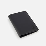 A closed BRUNELLO CUCINELLI Leather Wallet and Passport Holder, in black leather with a subtle embossed logo at the bottom right corner, is photographed on a plain white background. Made in Italy.