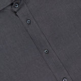 A close-up of the BRUNELLO CUCINELLI Linen Long Sleeve Shirt in dark grey shows its textured fabric, collar, buttons, and branded tag. This elegant men's shirt is expertly crafted in Italy.