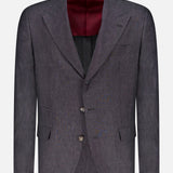 The BRUNELLO CUCINELLI Linen Single-breasted Suit Jacket features a dark grey design with three buttons, notched lapels, and front pockets, shown on a white background with a hint of maroon lining for added style.