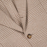 Close-up of the BRUNELLO CUCINELLI Plaid Wool-blend Sportcoat, featuring a tan houndstooth pattern with brown buttons and a glimpse of its red interior lining, highlighting the refined craftsmanship of this men's blazer.