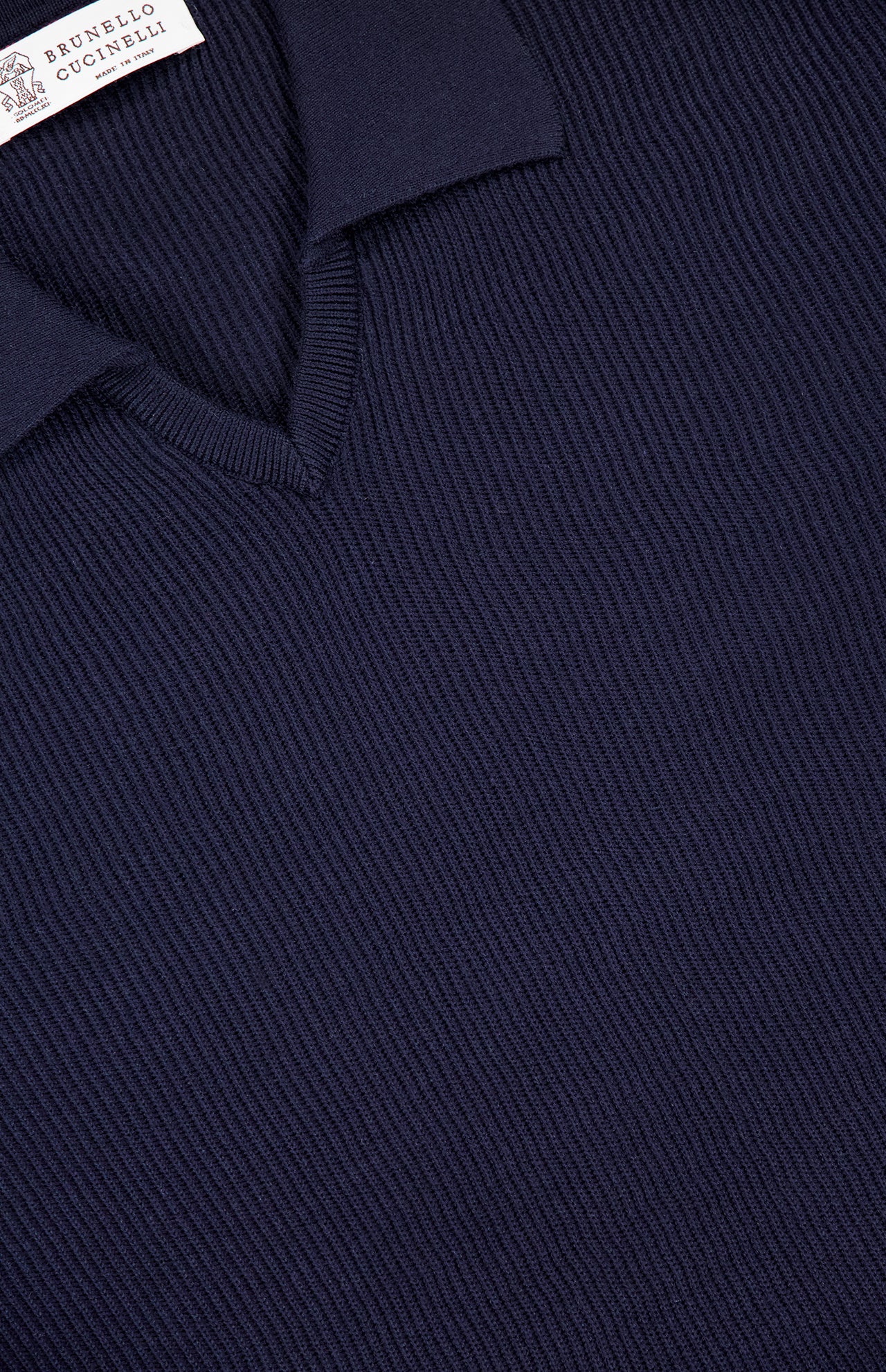 Close-up of a dark navy blue BRUNELLO CUCINELLI Polo Short Sleeve Sweater, featuring a V-neck and collar. The fine English rib knit texture and visible stitching showcase luxurious Italian craftsmanship.