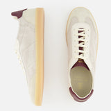 The Suede Leather Detailing Sneakers by BRUNELLO CUCINELLI feature beige washed suede, a subtle plaid pattern, white laces, gum soles, and maroon accents on the heel and tongue. Shown from side and top views against a white background.