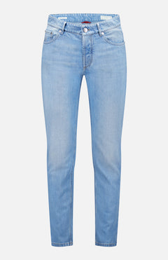 The Traditional Fit Light Denim jeans by BRUNELLO CUCINELLI feature a light blue wash with a classic five-pocket design and button closure, inspired by vintage denim, and are shown against a plain white background.