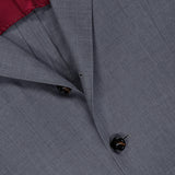 Close-up of the BRUNELLO CUCINELLI Wool and Silk Travel Blazer in grey, featuring a single-breasted design with dark buttons and a visible maroon inner lining. The refined wool and silk blend fabric offers a smooth texture, while lapel and pocket details are clearly shown—making this blazer an ideal travel jacket for any occasion.