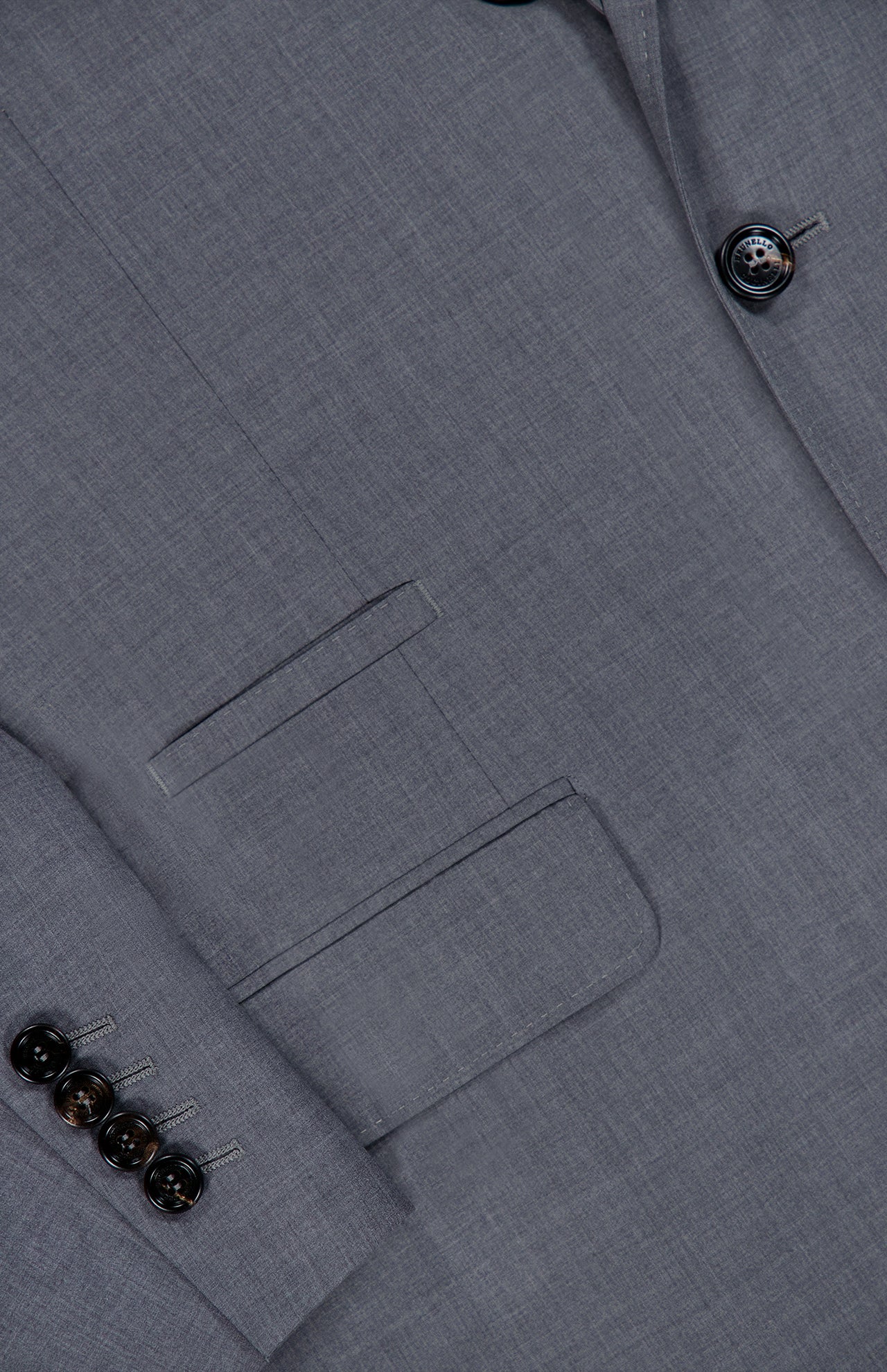 Close-up of the BRUNELLO CUCINELLI Wool and Silk Travel Blazer in grey, featuring a front pocket, a sleeve detailed with four dark buttons, and two buttons near the lapel. This single-breasted jacket seamlessly combines practicality with refined style, making it an ideal choice for any journey.