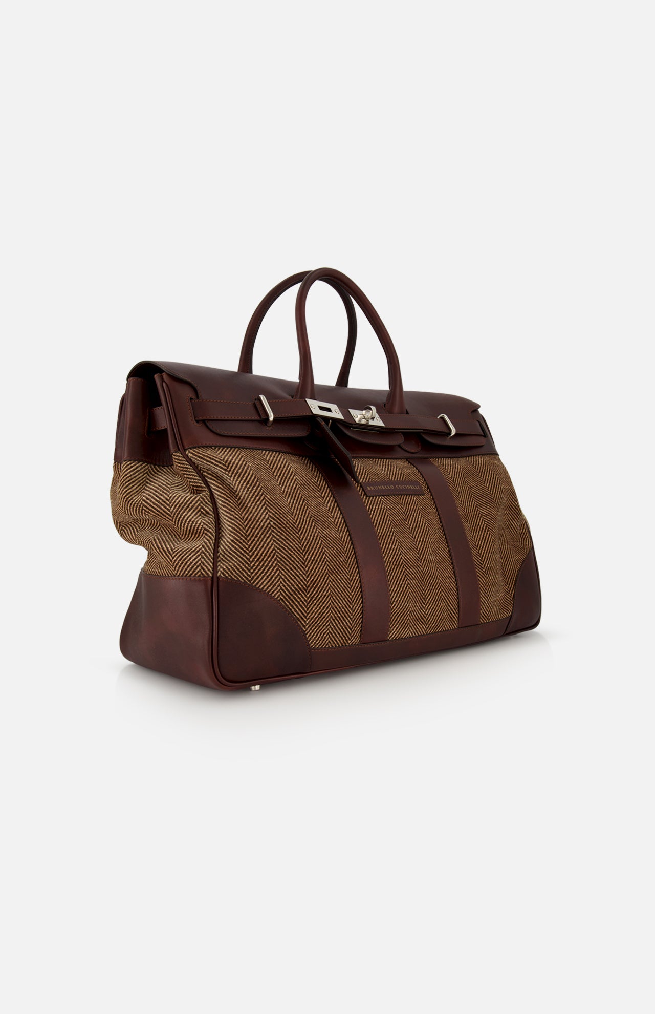 The BRUNELLO CUCINELLI Travel Duffle Bag with Chevron-effect showcases large brown leather accents paired with herringbone-patterned fabric panels for a refined, country-inspired look. Featuring two handles, a flap closure with metal hardware, and a structured silhouette, the bag is elegantly displayed against a plain white background.