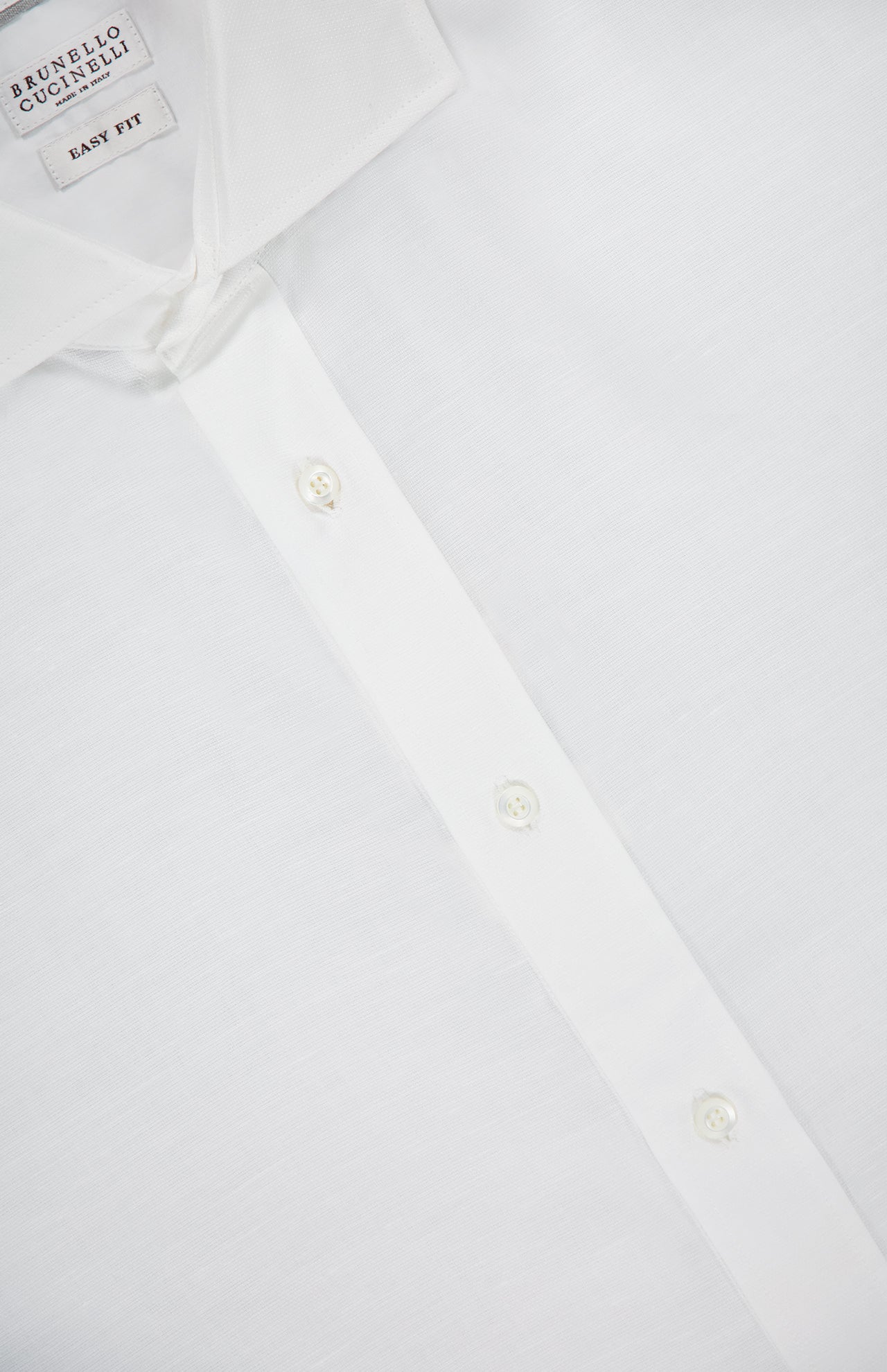Close-up of a Brunello Cucinelli Twill Melange Dress Shirt featuring a pointed collar, three visible buttons, and an Easy Fit label. The cotton-linen blend fabric appears smooth and slightly textured for timeless menswear style.