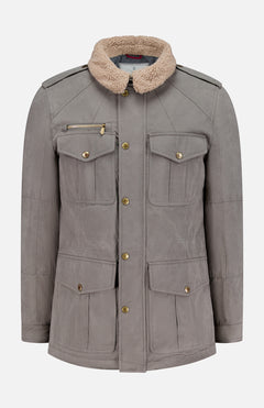 The BRUNELLO CUCINELLI Water Resistant Safari Jacket features a gray design with four front flap pockets, gold buttons, a zippered left chest pocket, shoulder epaulets, and a detachable beige shearling collar. The jacket is shown against a white background.