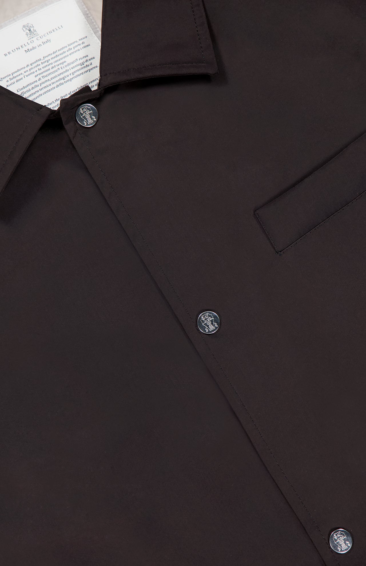 Close-up of a dark brown button-up shirt with pointed collar, visible buttons, chest pocket, and part of a white label—ideal for layering under the BRUNELLO CUCINELLI Water Resistant Vest for versatile style.