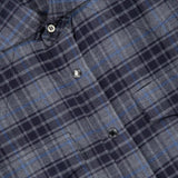 Close-up of the BRUNELLO CUCINELLI Western Cotton Plaid Shirt, featuring blue, gray, and black plaid with snap buttons and a visible brand label at the collar, crafted in the style of a cotton madras shirt.