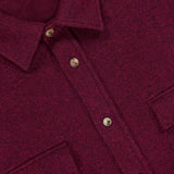 Close-up of a burgundy BRUNELLO CUCINELLI Snap-front Western Overshirt, crafted from a luxurious virgin wool, cashmere, and silk blend, featuring a snap-front closure, pointed collar, and two chest pockets with button flaps.