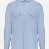 Introducing the Cotton and Cashmere Western Shirt by BRUNELLO CUCINELLI: a light blue, long-sleeve button-up shirt featuring a collar and two front chest pockets with buttoned flaps. Showcasing classic western wear details with a tailored design, this premium shirt is displayed against a plain white background.