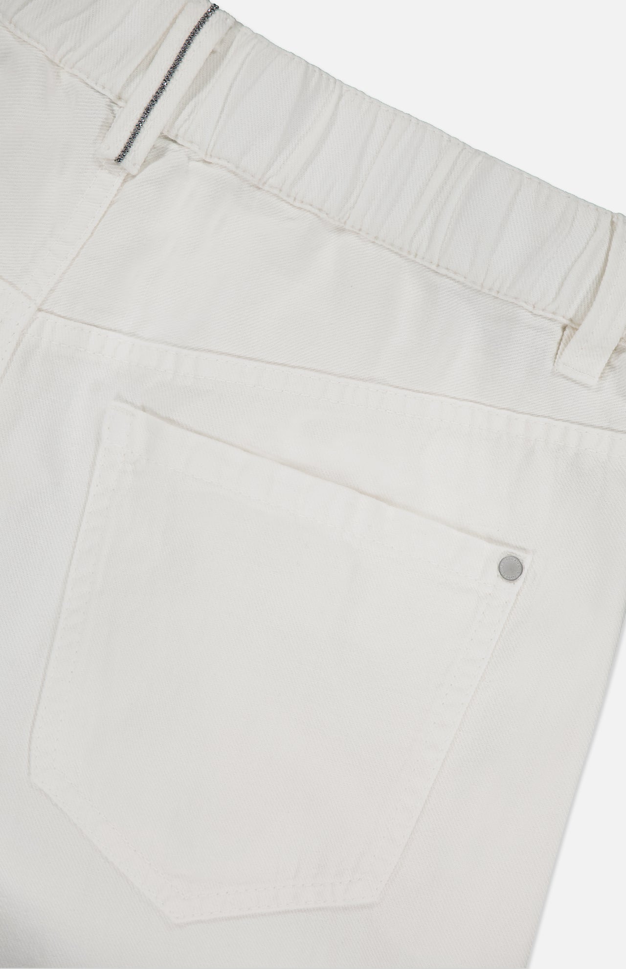 Close-up of the back of BRUNELLO CUCINELLI Piece-Dyed Cotton Pull-On Jeans, showing an elastic waistband, belt loops, and a single back pocket with a metal rivet at the corner.
