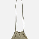 The BRUNELLO CUCINELLI Soft Suede Mini Pouchette Bag features light olive-green suede and leather, a long slender shoulder strap, and is showcased against a plain white background.