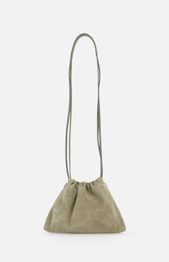 The Soft Suede Mini Pouchette Bag by BRUNELLO CUCINELLI features light olive green suede and leather, a long thin strap, and a soft, slouchy silhouette with minimalist design. Shown against a plain white background.