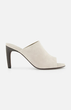 The BRUNELLO CUCINELLI Suede Curved Monili 80MM Mule Heel, in beige suede with a high tapered heel and minimalist slip-on design, is displayed in side view against a white background.