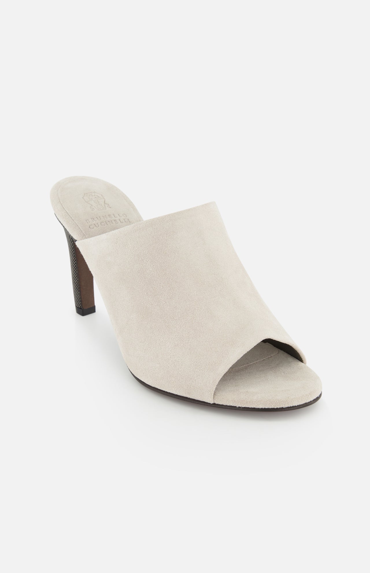 The BRUNELLO CUCINELLI Suede Curved Monili 80MM Mule Heel is a beige open-toe suede mule with a chunky brown heel and elegant monili embroidery, shown on a white background.