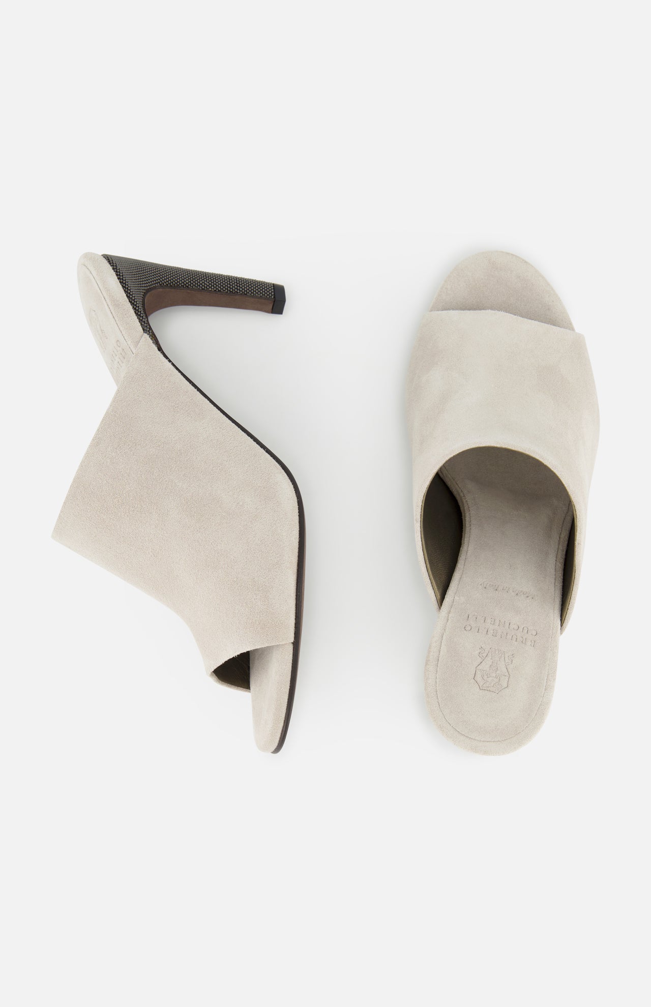 A pair of beige BRUNELLO CUCINELLI Suede Curved Monili 80MM Mule Heels is displayed from the side and top, showcasing open toes, block heels, and a minimalist design against a white background.