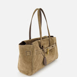The Explorer Suede Medium Shopper Bag by BRUNELLO CUCINELLI is a taupe shoulder bag crafted from suede, featuring double handles, a strap and buckle closure, and an accent brown leather tag. This travel-inspired accessory is displayed against a plain white background.