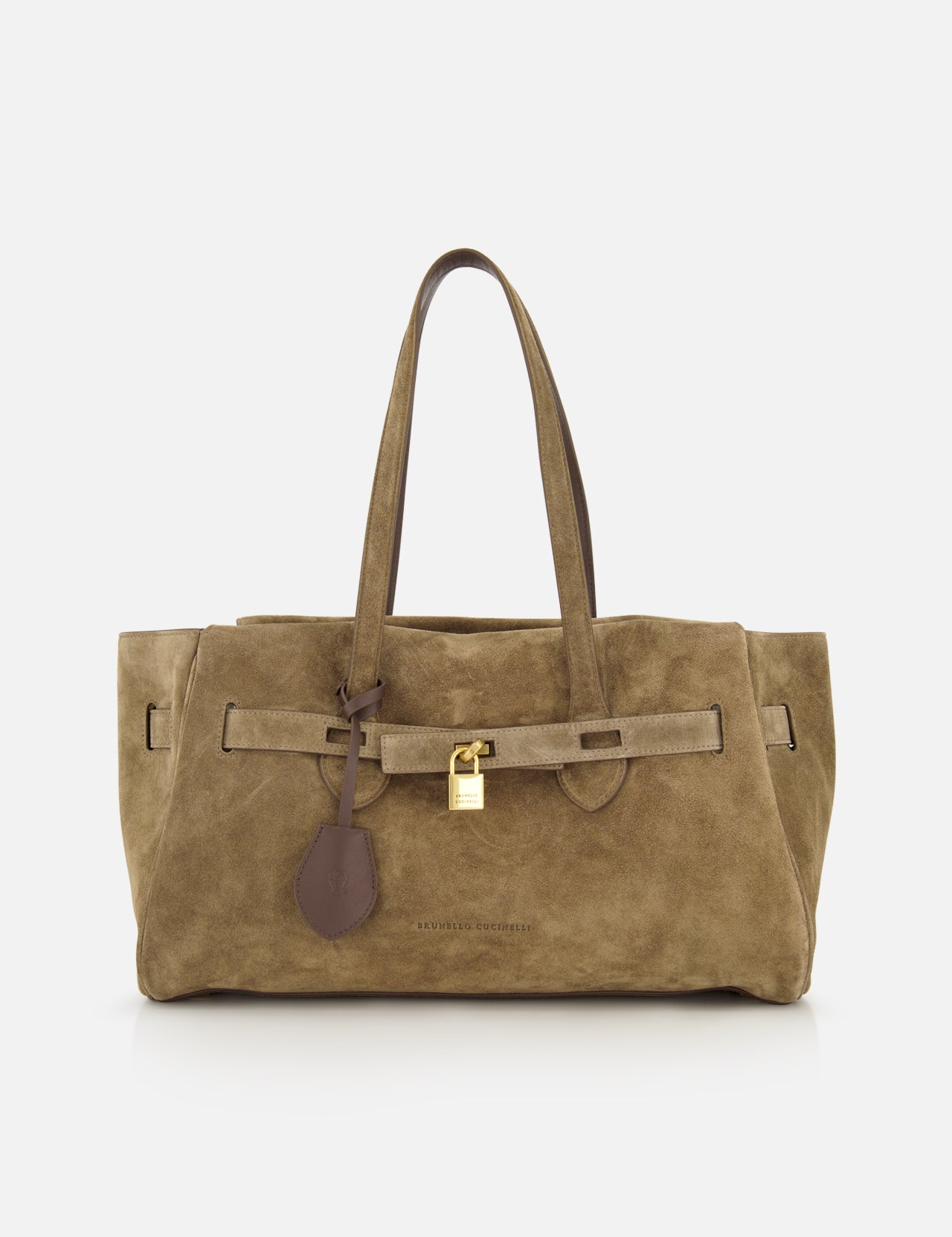 The Explorer Suede Medium Shopper Bag by BRUNELLO CUCINELLI is a medium-sized tan suede shoulder bag, expertly crafted in Italy. It features two handles, a distinctive leather strap detail, and a gold padlock accent on the front, all showcased against a plain white background.