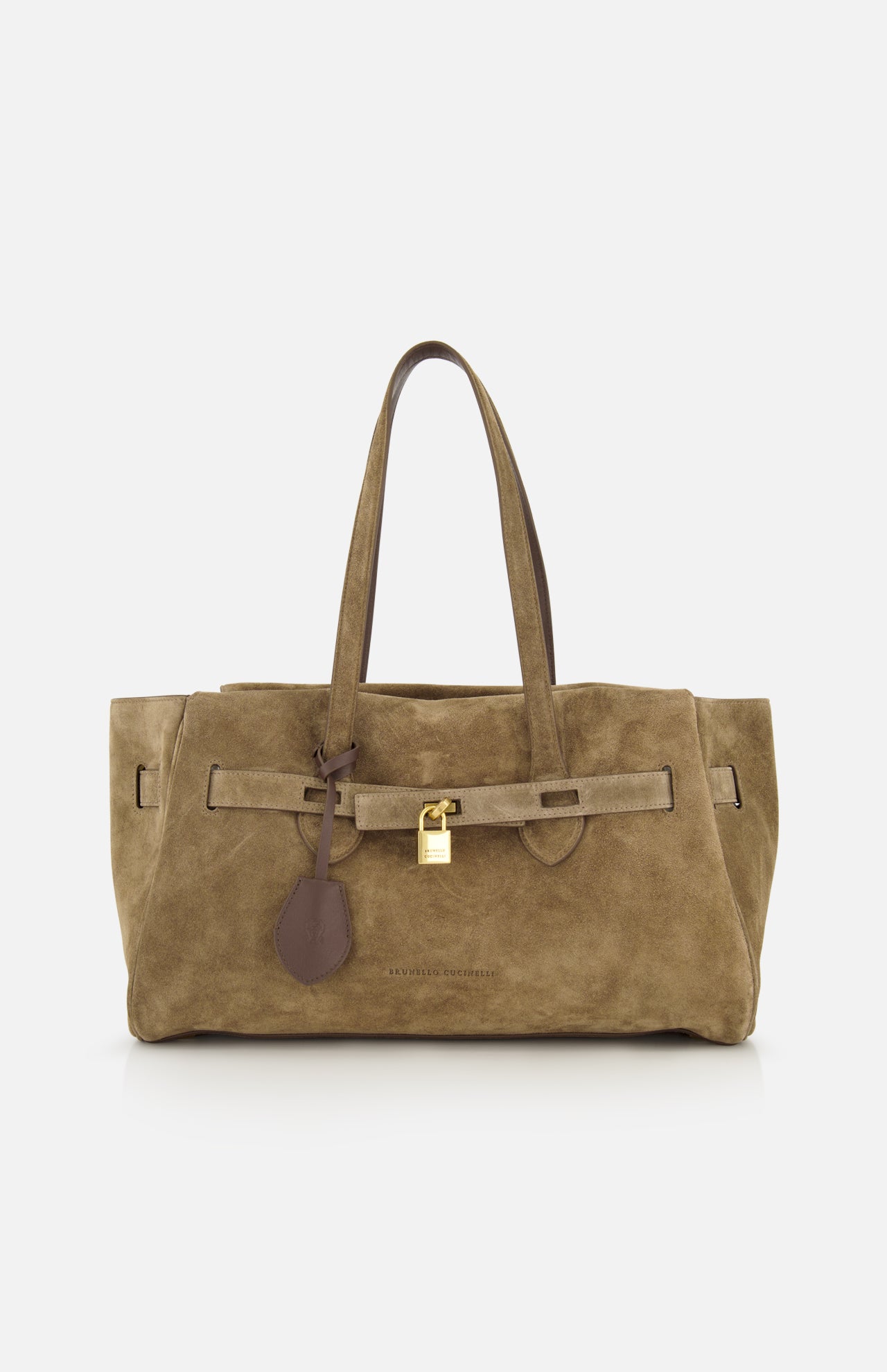 The Explorer Suede Medium Shopper Bag by BRUNELLO CUCINELLI is a medium-sized tan suede shoulder bag, expertly crafted in Italy. It features two handles, a distinctive leather strap detail, and a gold padlock accent on the front, all showcased against a plain white background.