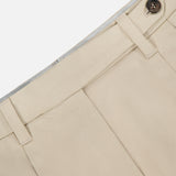 Close-up of the waist and upper section of BRUNELLO CUCINELLI Cotton Linen Bull Bermuda Pleated Short, highlighting the waistband with belt loops, button closure, pleats, and a partial pocket against a plain background.