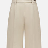 The BRUNELLO CUCINELLI Cotton Linen Bull Bermuda Pleated Short features front pleats, belt loops, and a button detail at the waistband, shown in beige on a plain white background.